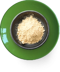 A black bowl with beige powder on a green plate.