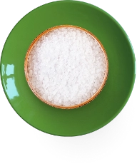 A bowl of white salt on a green plate.