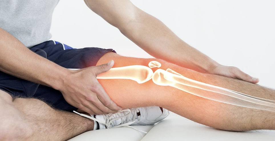 Person massaging a knee with a highlighted skeletal structure overlay.