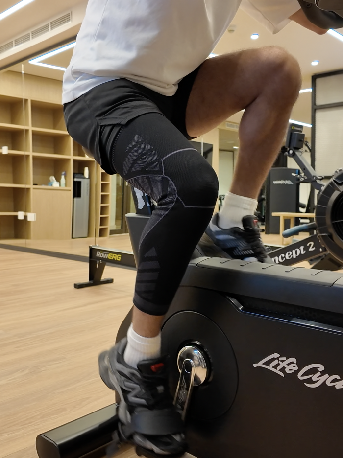 Person exercising on a stationary bike in a gym setting.