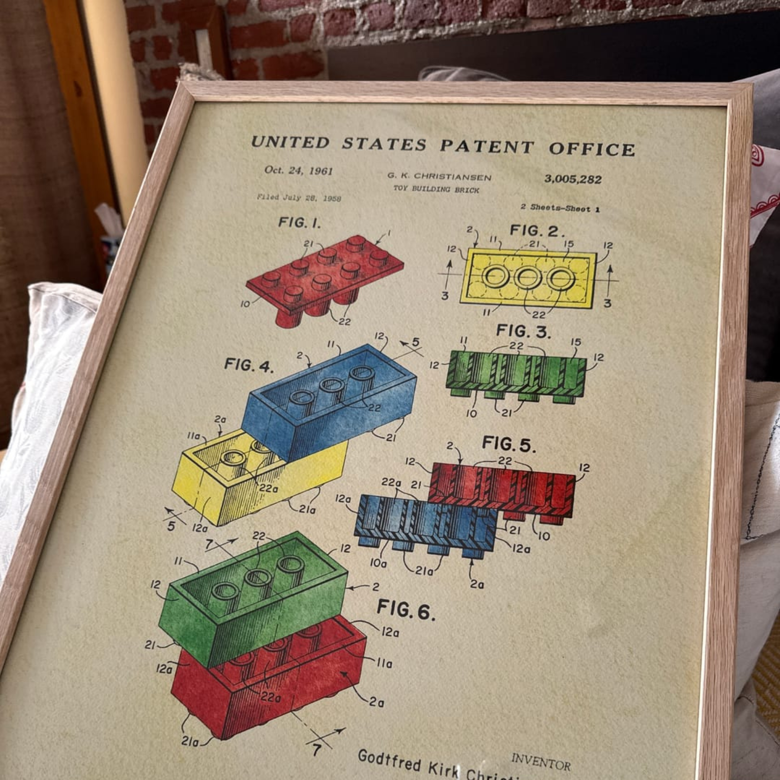 Framed patent illustration of colorful toy building bricks from 1961.