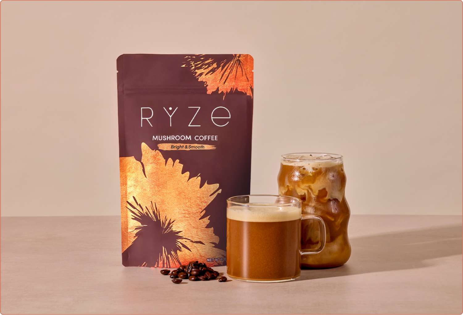 Package of mushroom coffee with two glass mugs, one iced, on a table.