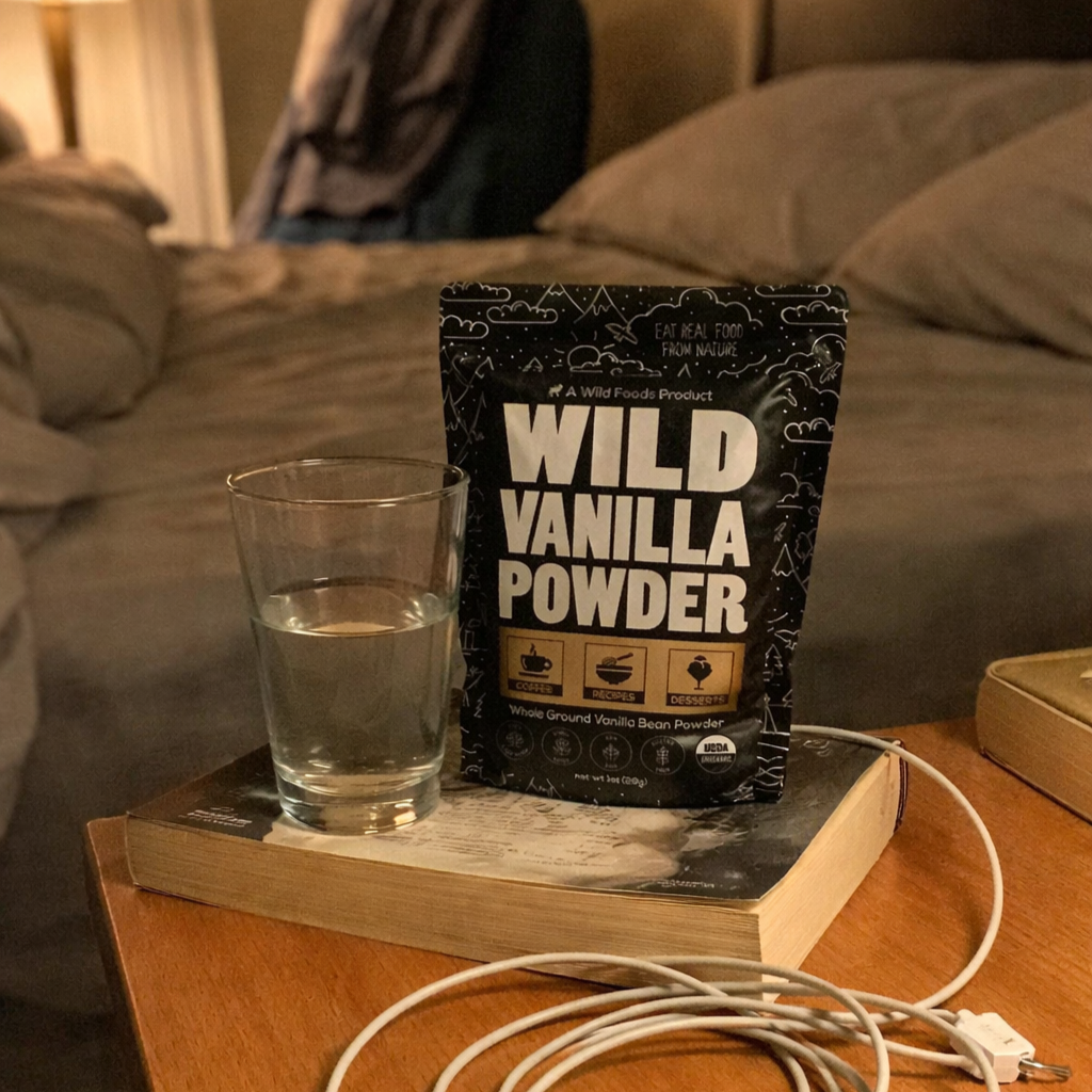 Packet of wild vanilla powder and glass of water on a bedside table.