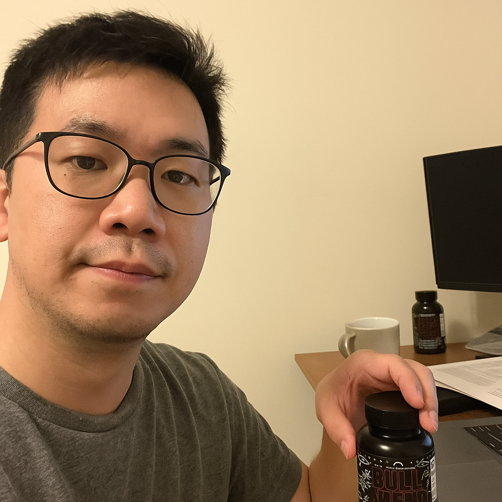 Person holding a bottle at a desk with a computer and papers.