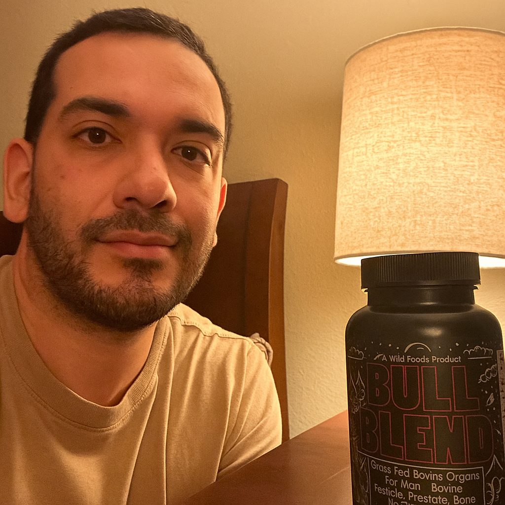 Person sitting by a table lamp with a 'Bull Blend' supplement bottle.