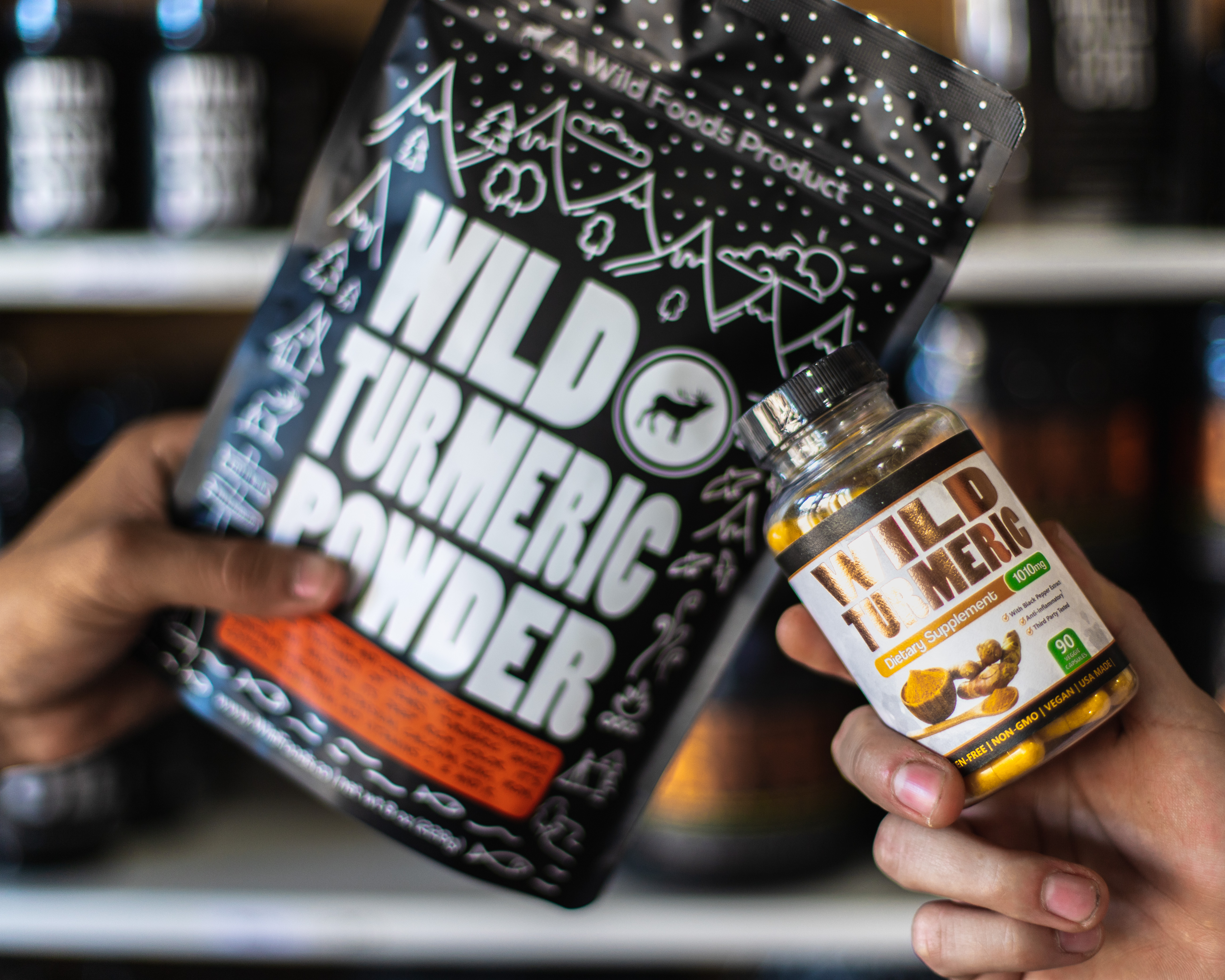 Two hands holding wild turmeric powder and supplement bottle.