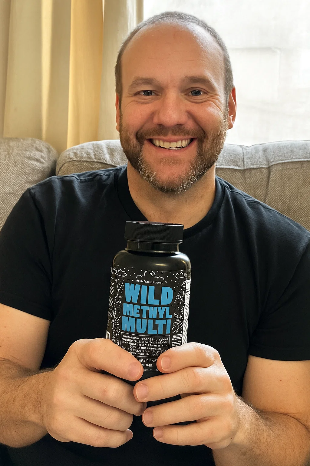 Person holding a bottle labeled 'Wild Methyl Multi' while smiling.