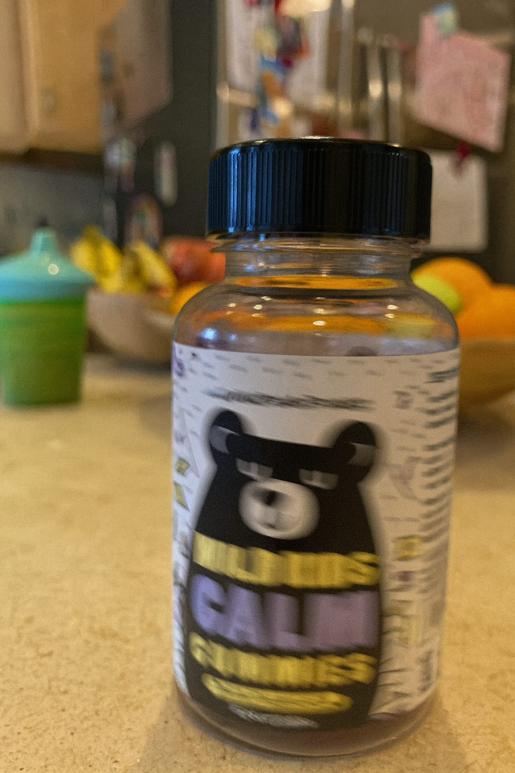 Jar of gummies with a bear illustration on a kitchen counter.
