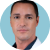 A person in a white coat against a blue background.