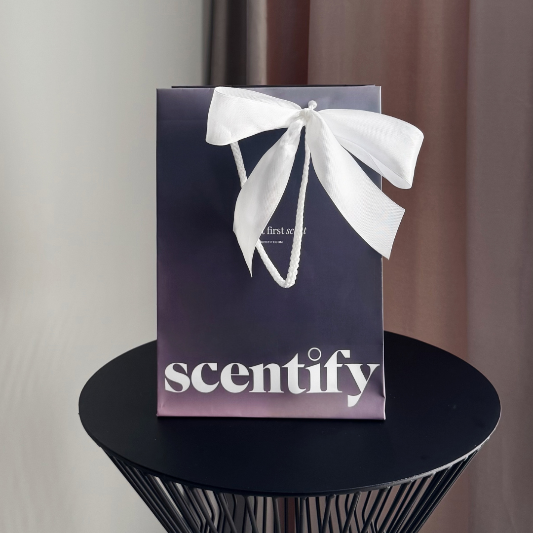 Gift bag with a white bow on a black table.
