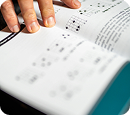 A close-up of a hand resting on an open music book showing chord diagrams.