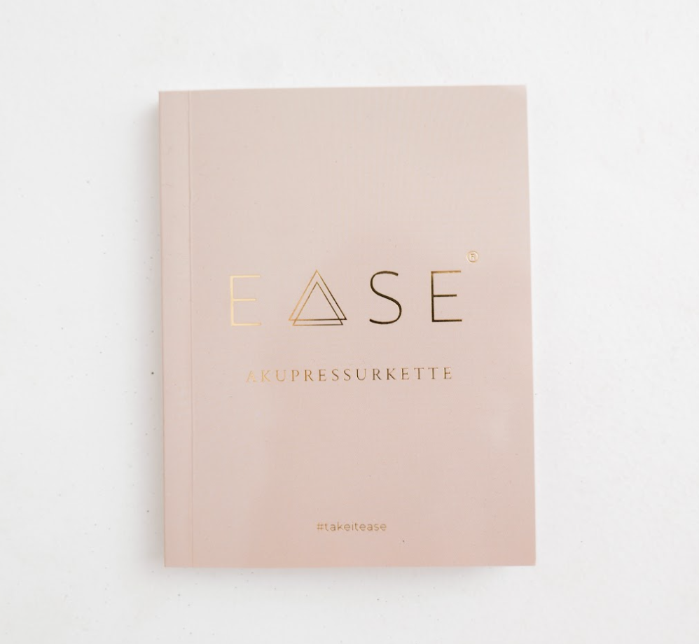 Beige book cover with 'EASE' and 'AKUPRESSURKETTE' in gold text.