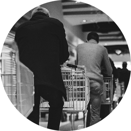 Shoppers in a queue with grocery carts in a store.