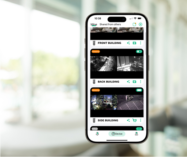 Smartphone displaying security camera feeds labeled 'Front,' 'Back,' and 'Side Building' indoors.