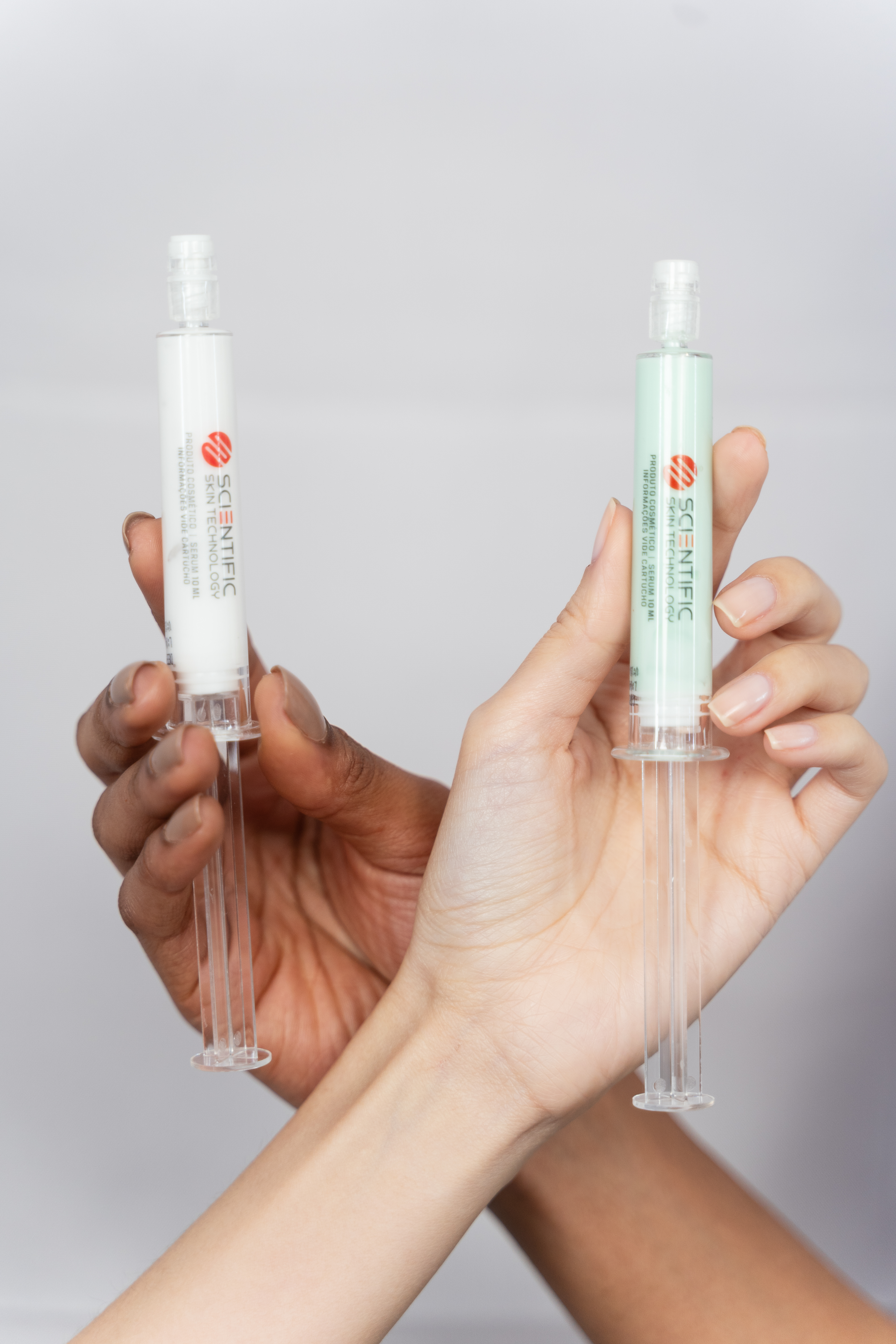 White cosmetic bottles and stackable containers on a neutral background.