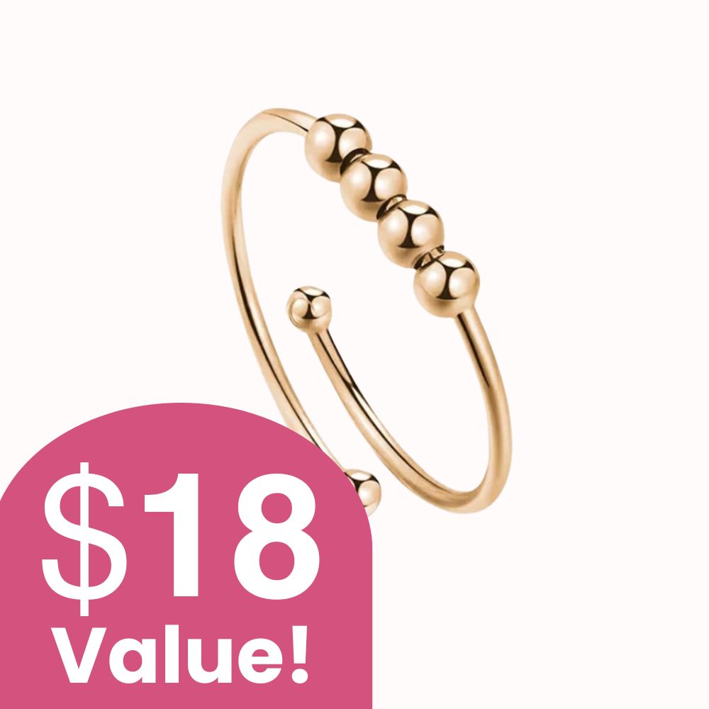 A gold-colored, open-ended ring with four beads on the band against a white background.
