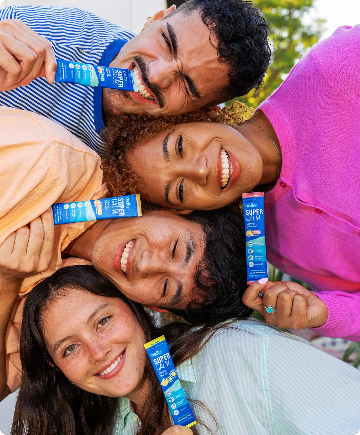 Four people smiling, holding blue packets labeled 'Super Calm.'
