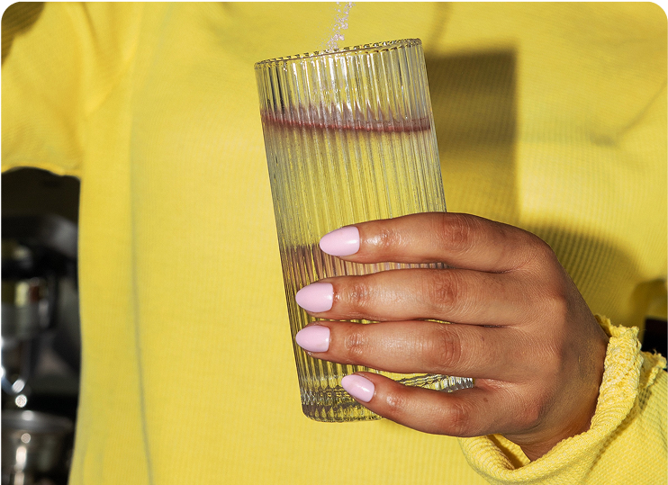 Filling a glass with water for Oluna Calming Drink Mix