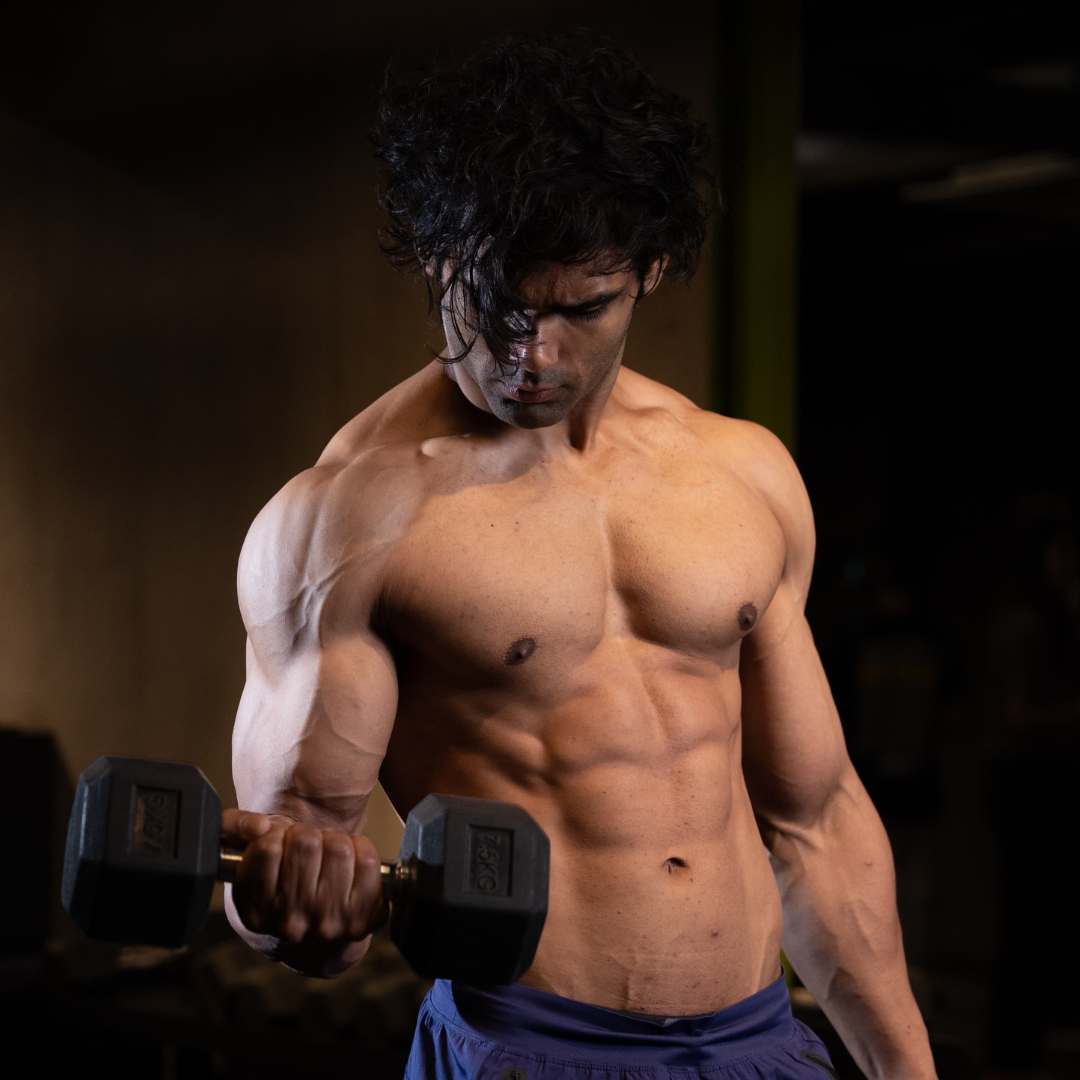 Man lifting a dumbbell in a gym setting.