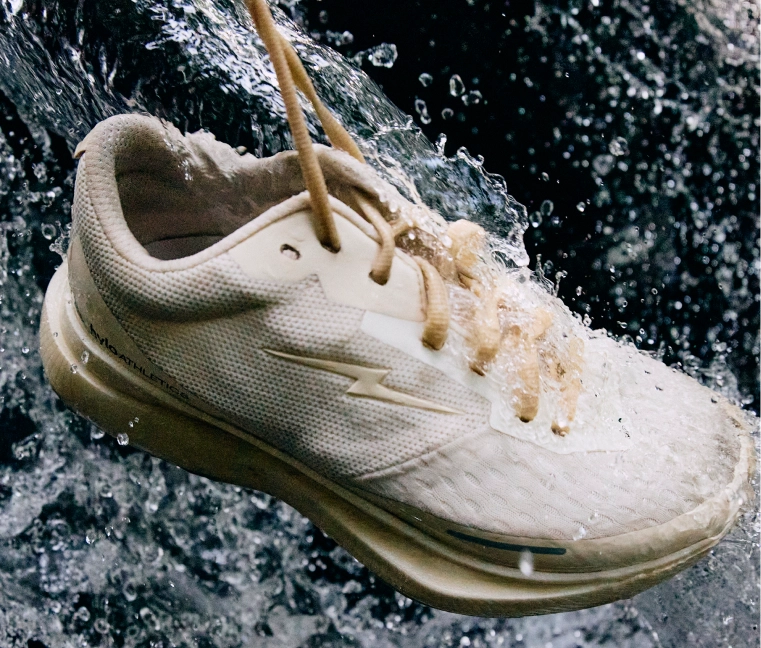 White sneaker with water splashing around it.