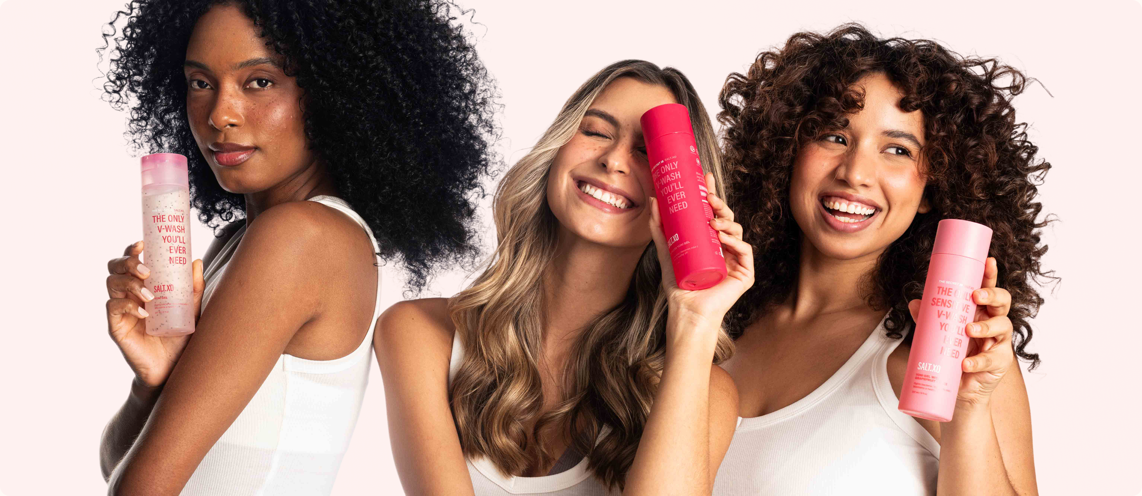 Three diverse smiling women with different hair types holding pink Salt.xo bottles, representing happy customers using natural feminine hygiene products