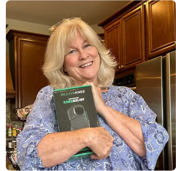 A smiling woman in a kitchen holds a box for a Rejuvaknee Advanced Knee Relief device.