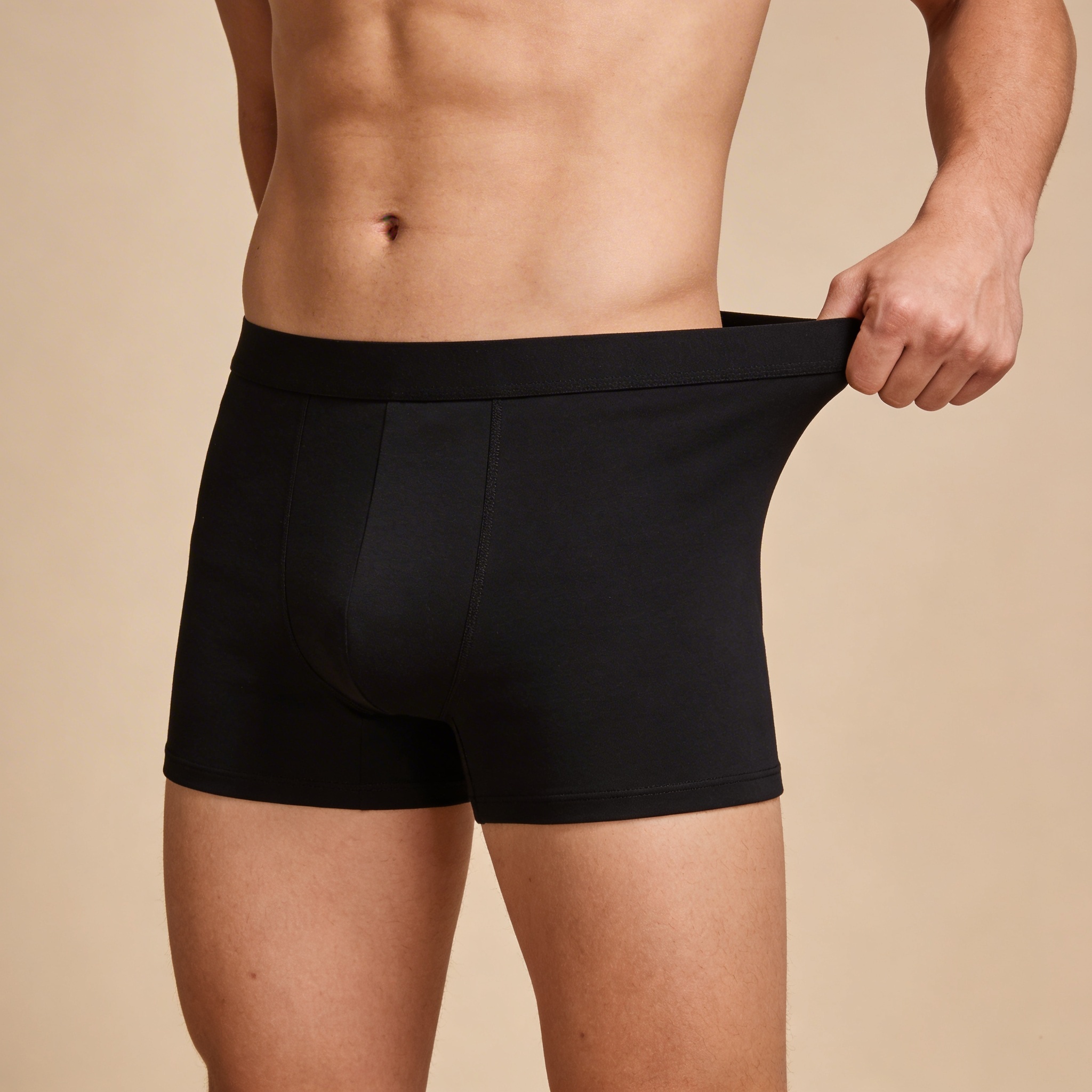 Person wearing high-waisted brown underwear and a white crop top.