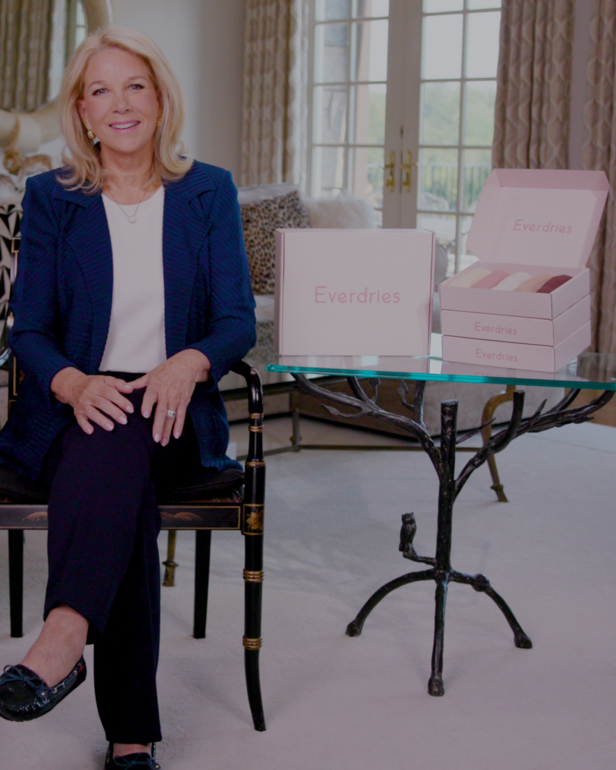 Woman sitting beside Everdries product boxes on a glass table.
