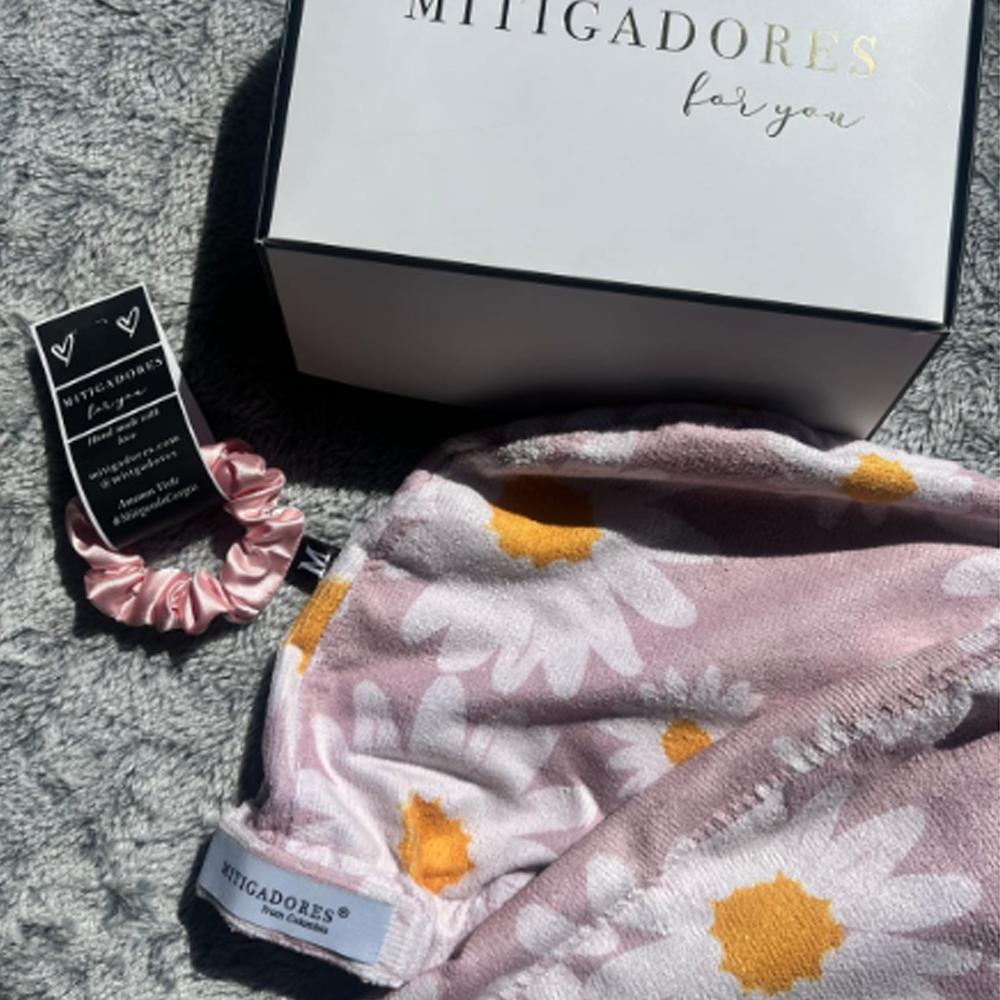 Gift box with floral fabric and pink hair scrunchie on gray surface.