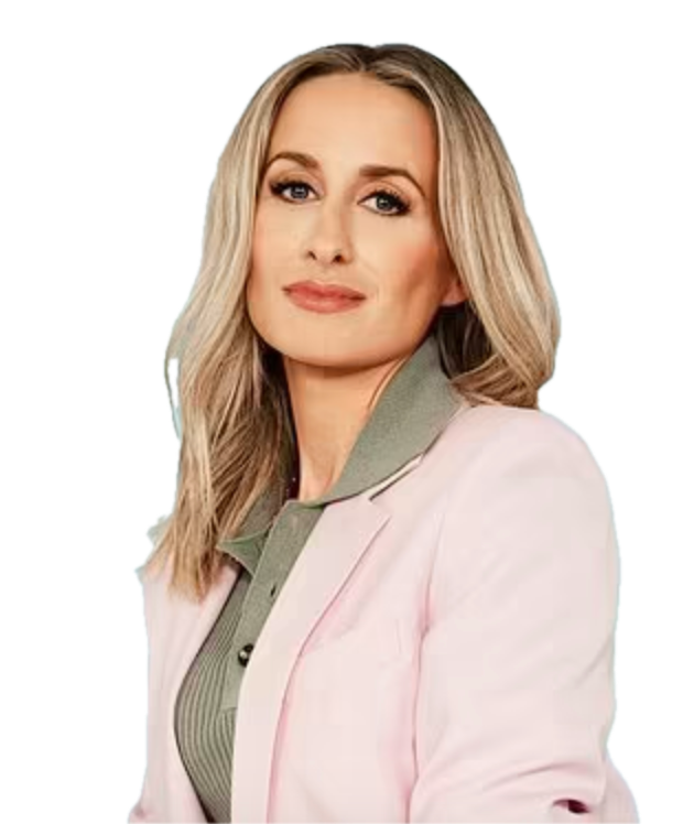 Person with long blonde hair wearing a pink blazer and gray top.