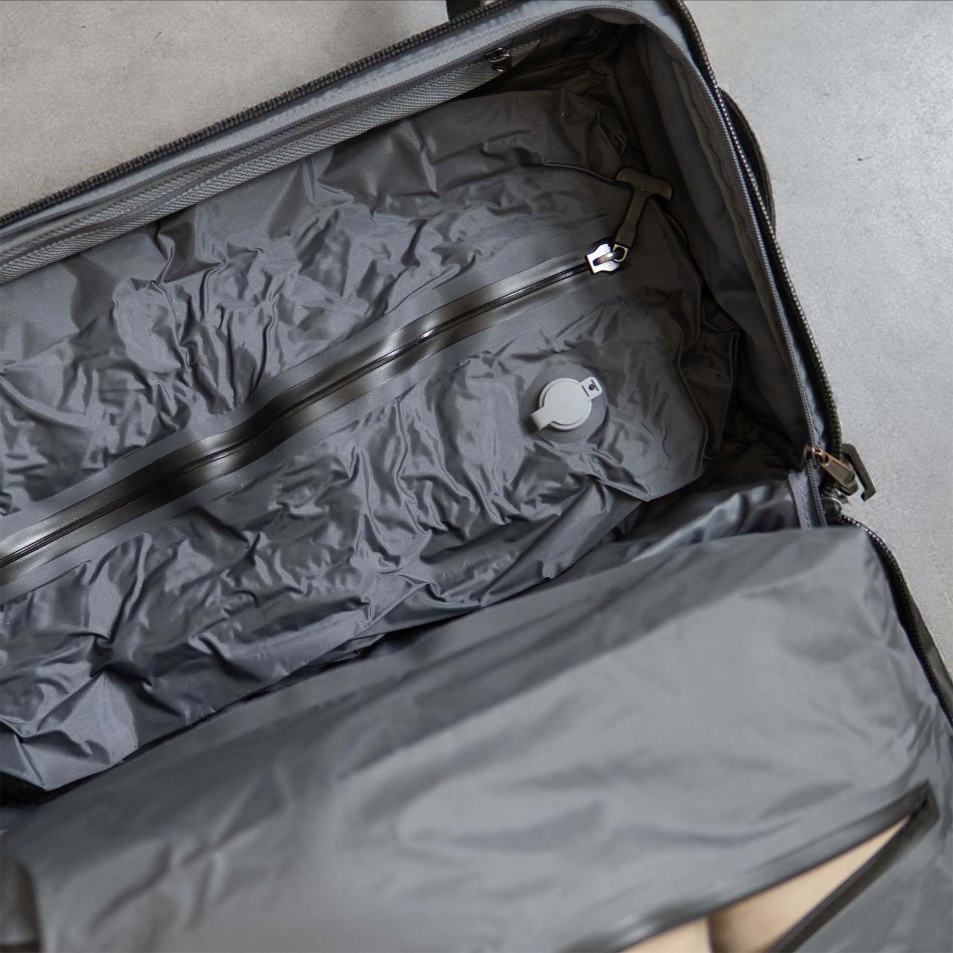 Open gray suitcase with a zipper and a circular dial inside.