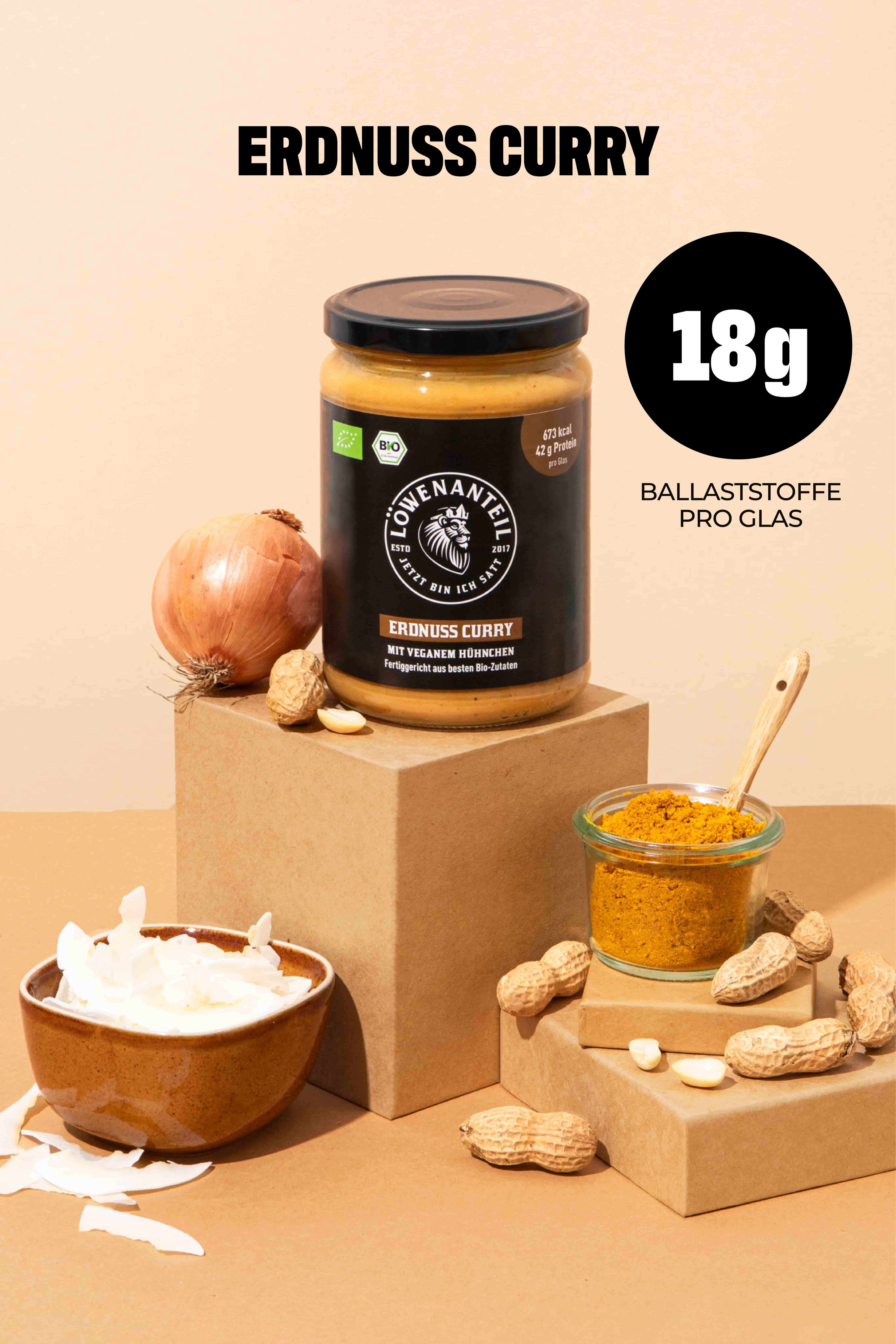A jar of Löwenanteil brand peanut curry displayed with its ingredients: onion, peanuts, coconut, and curry powder.