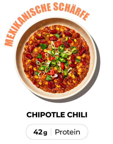 A top-down view of a bowl of chipotle chili, garnished with sliced jalapeños and spring onions.