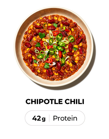 Bowl of chipotle chili with beans, corn, and sliced peppers, labeled with protein content.