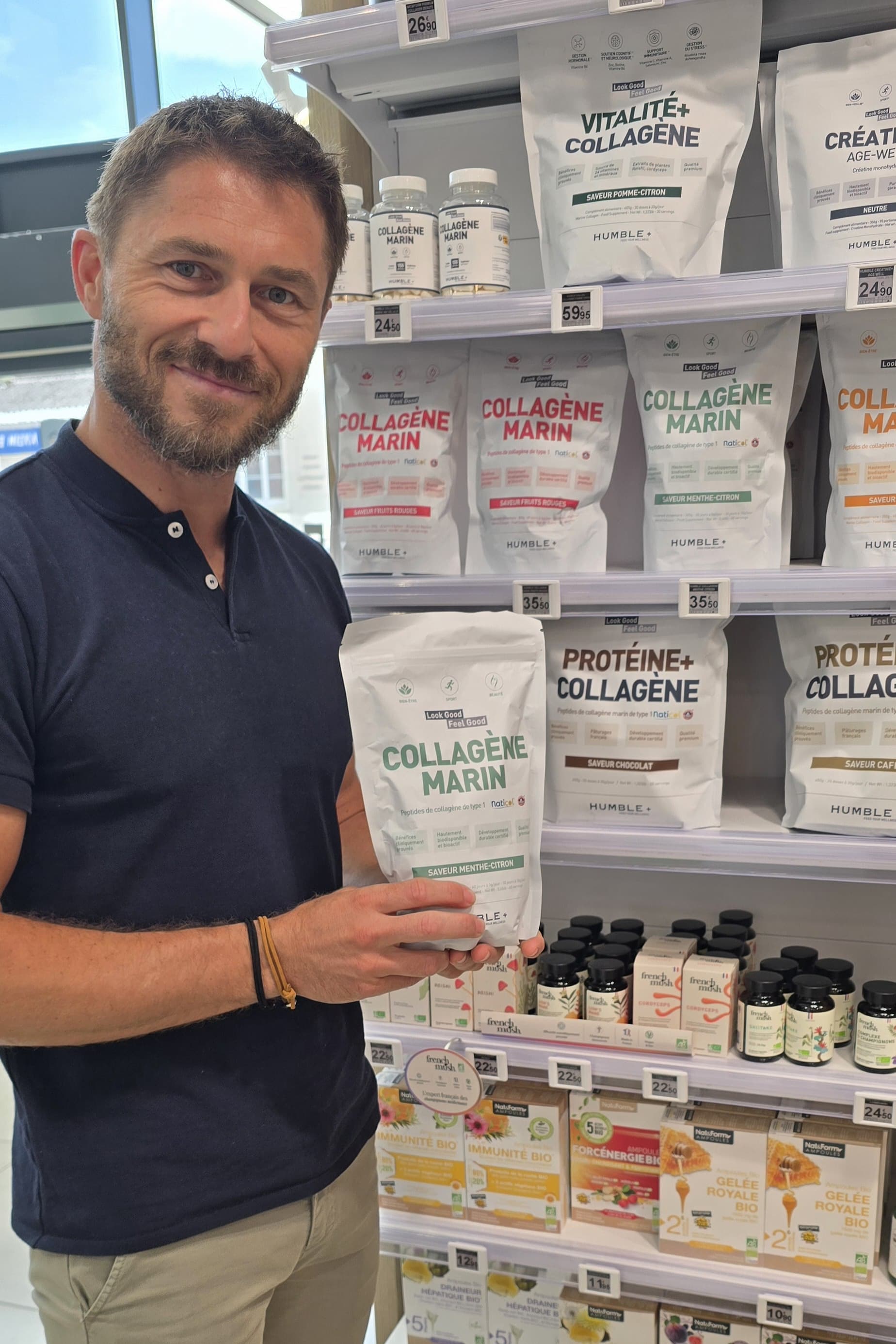 Man holding a pouch of marine collagen in a store aisle.