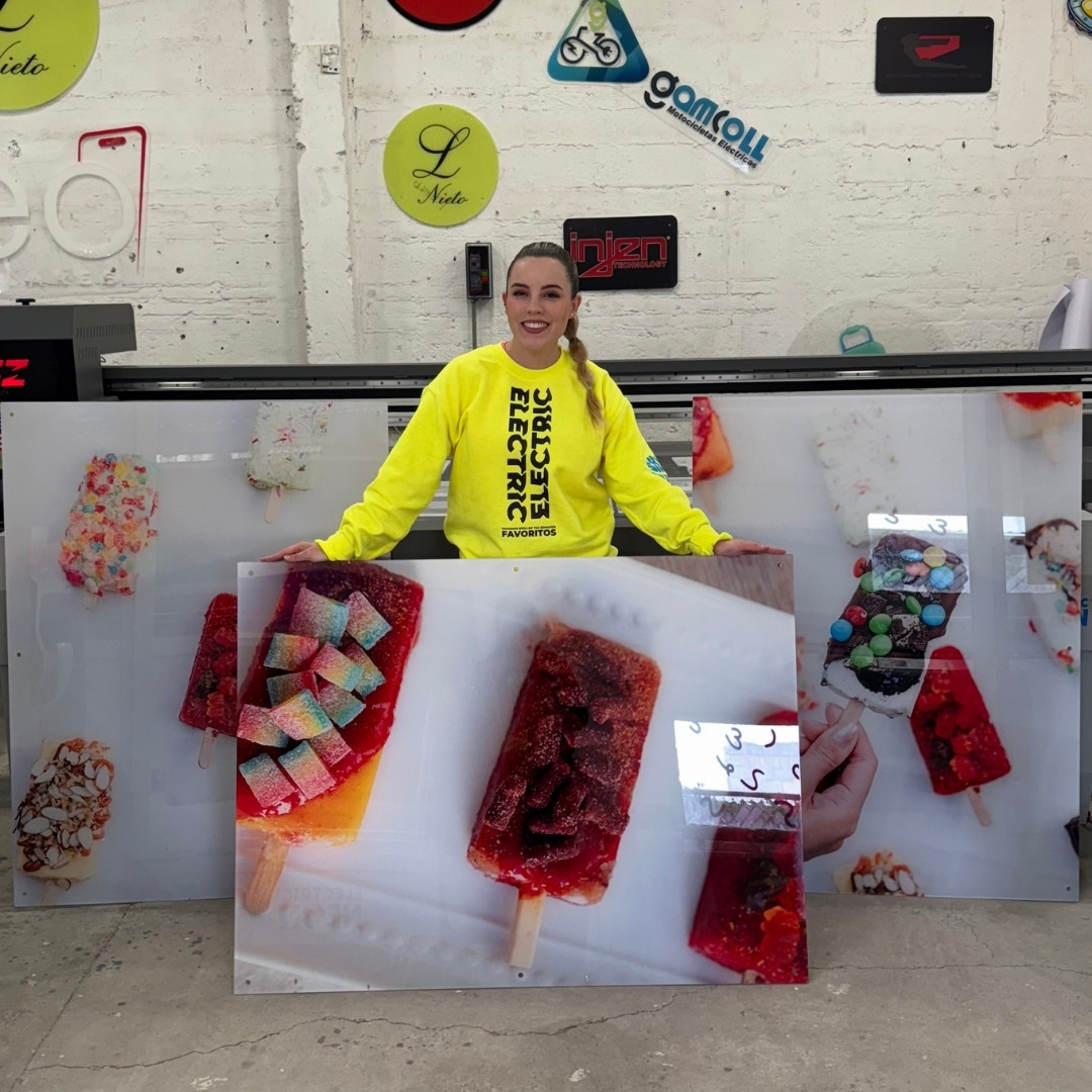 Person holding large images of colorful popsicles in a workshop.