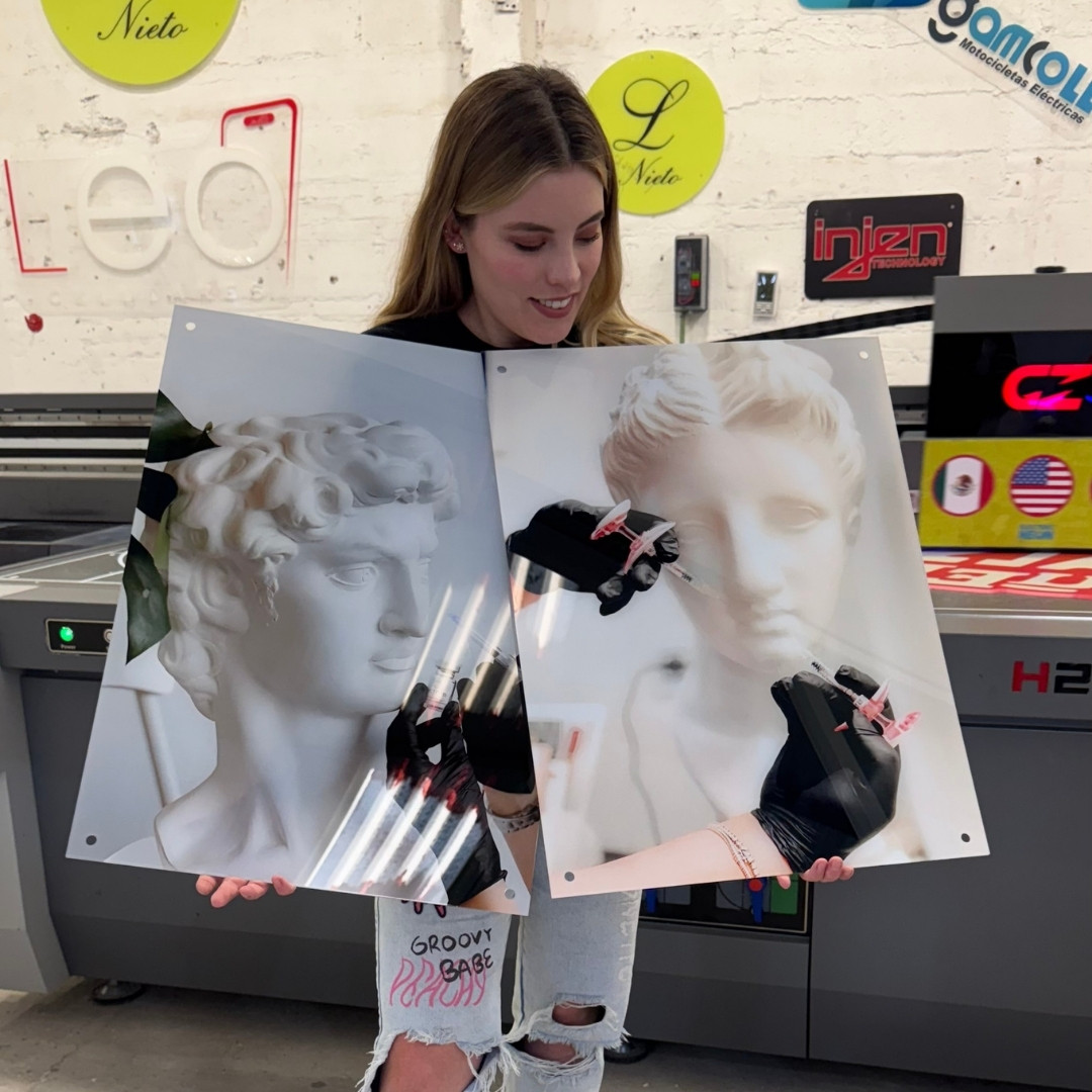 Person holding two printed images of classical sculptures.