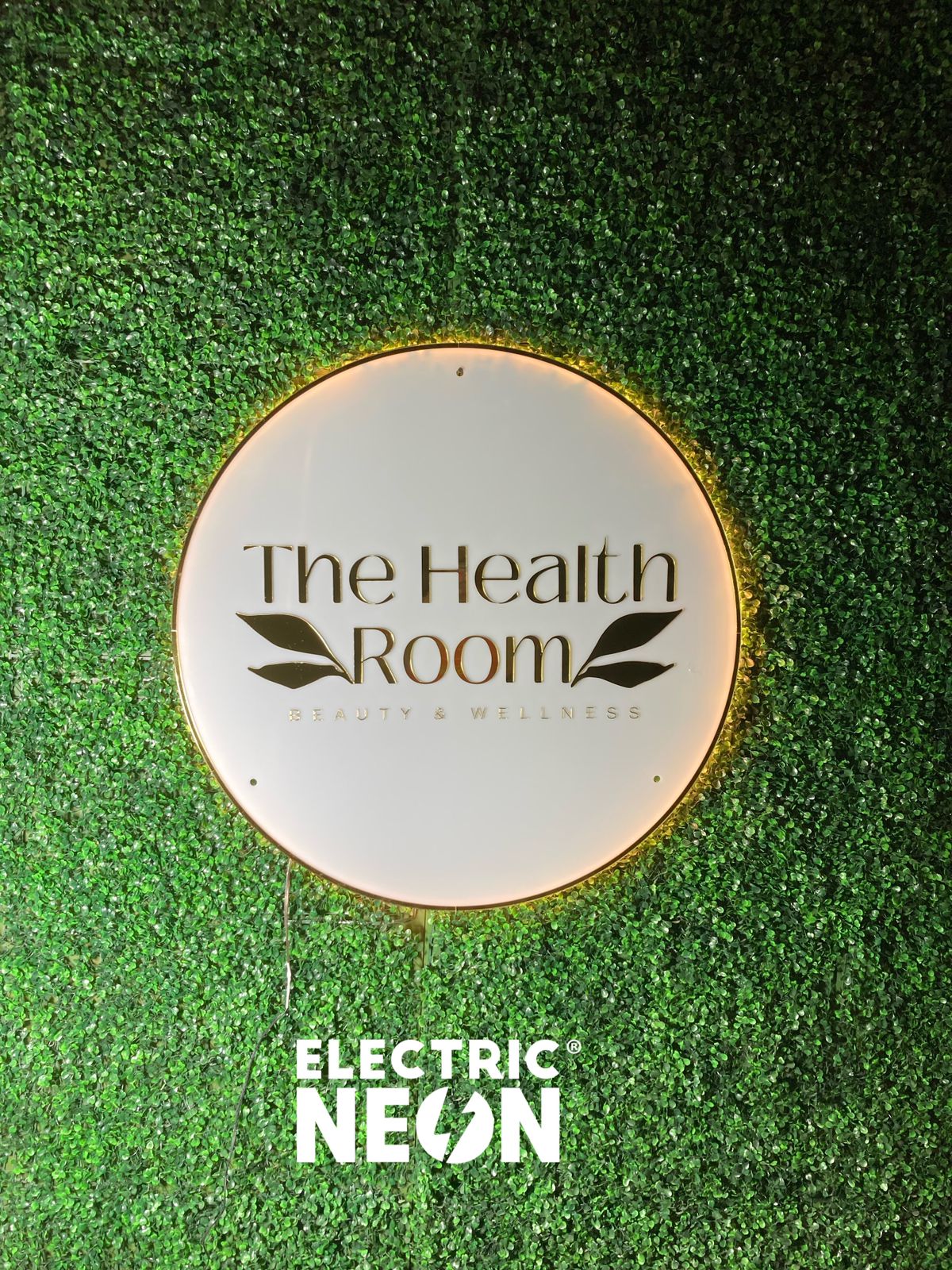 Circular sign reading 'The Health Room' on a green leafy background.