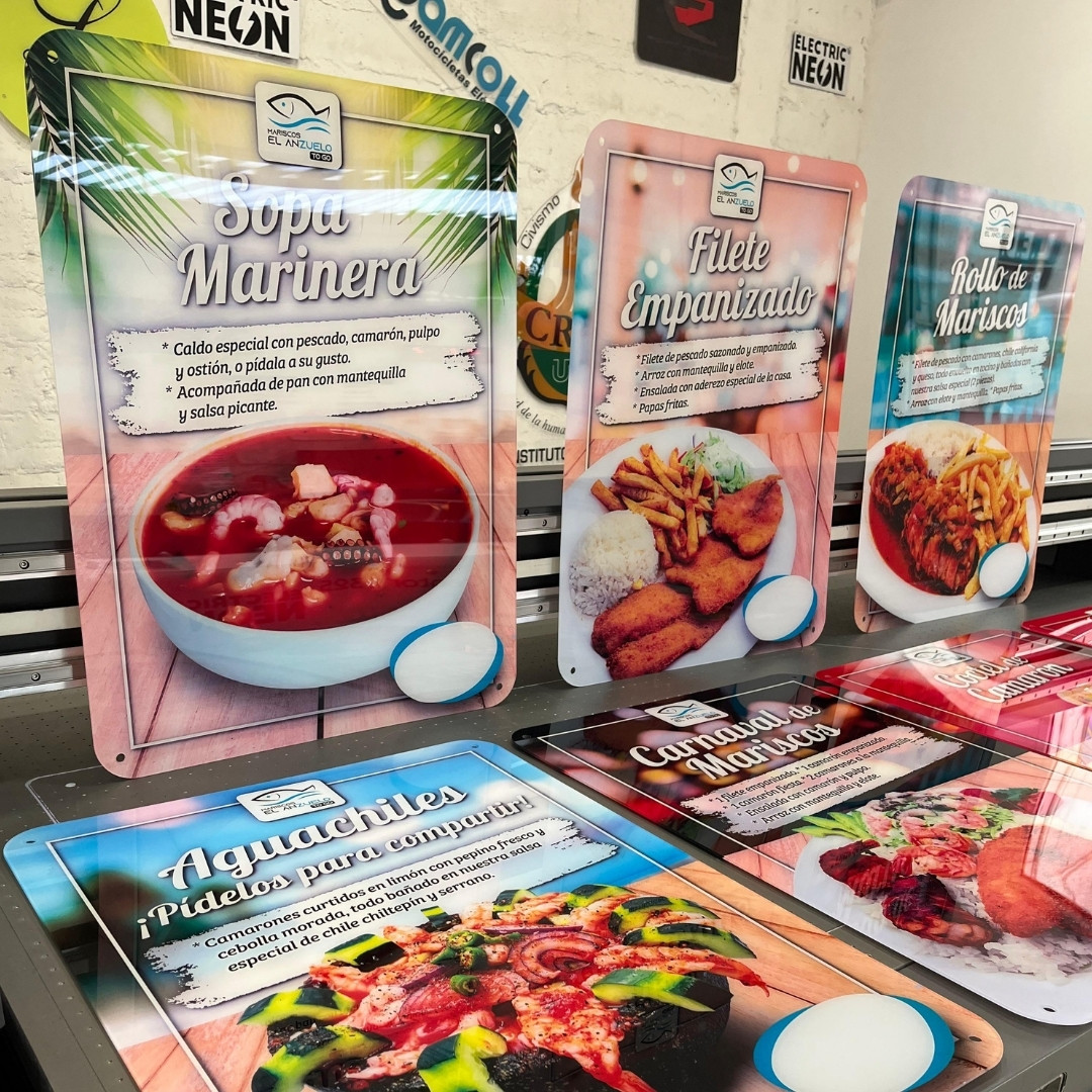 Colorful food and drink posters displayed on a printing machine.