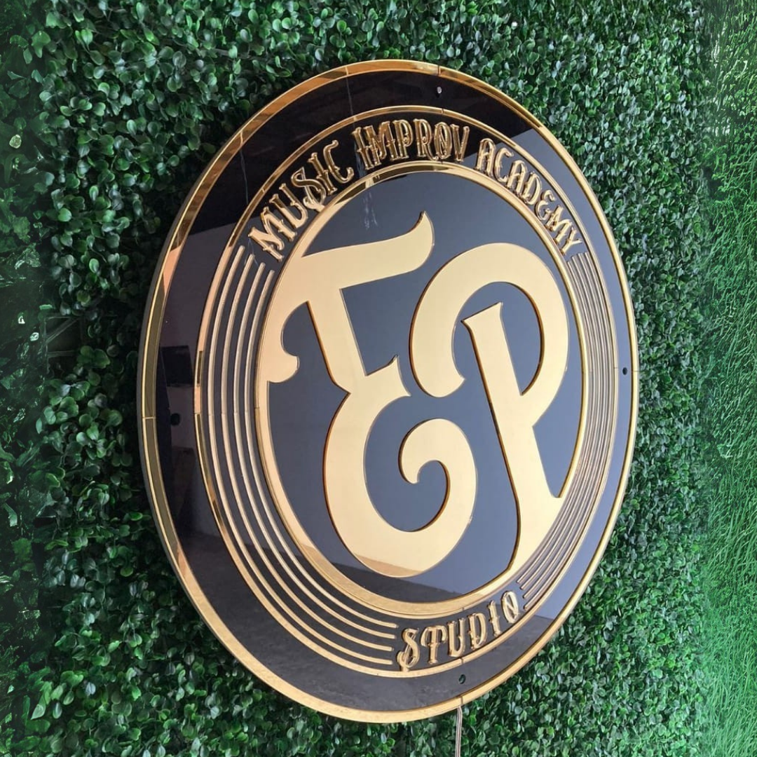 Circular sign with 'EP Music Improv Academy Studio' on a leafy background.