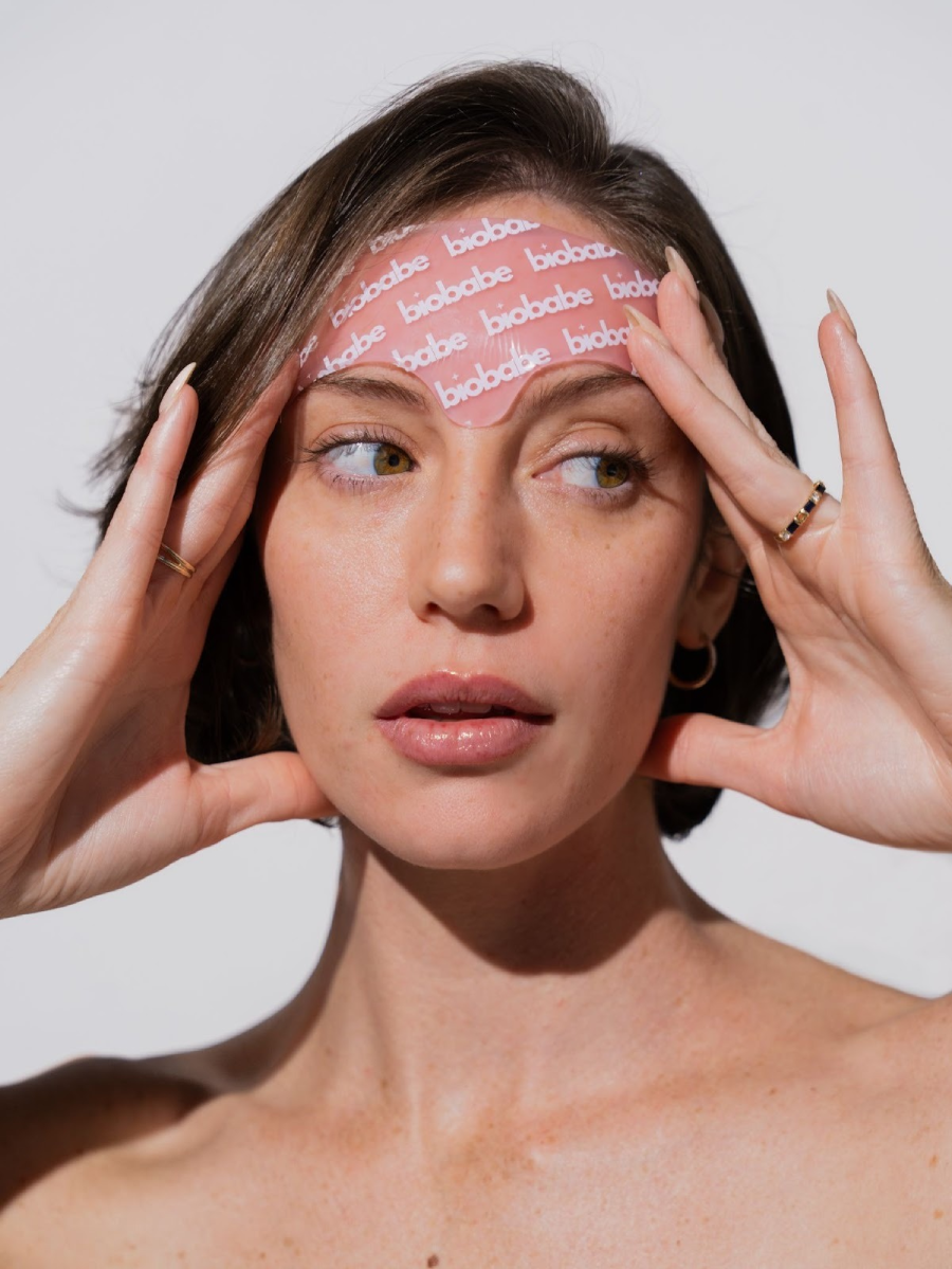 Woman with pink patch on forehead labeled 'biobabe'