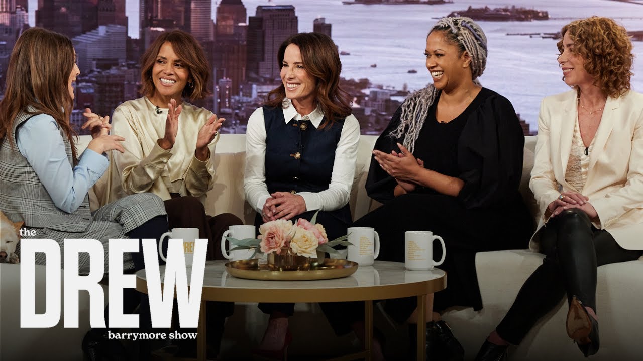 Five women sitting on a talk show set, smiling and clapping.