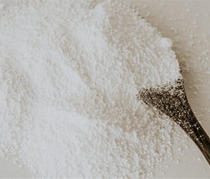 A spoon in a pile of white powder on a surface.