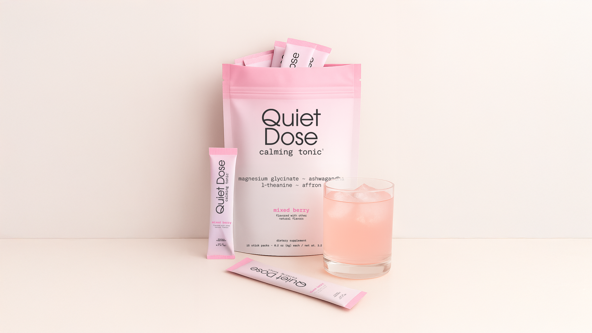 Pink packet and glass with pink drink labeled 'Quiet Dose calming tonic.'
