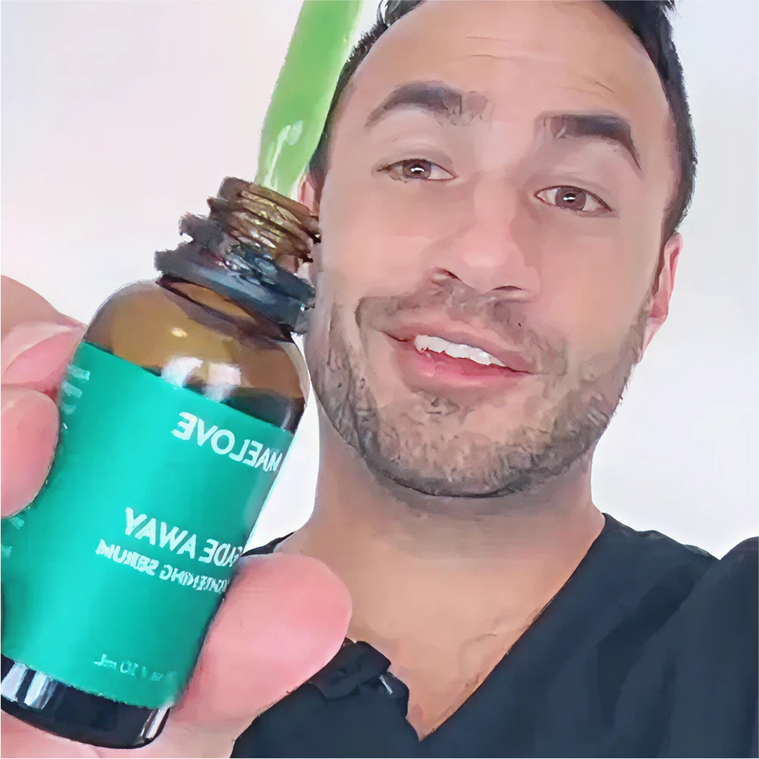 Person holding a small bottle with a green label, smiling at the camera.