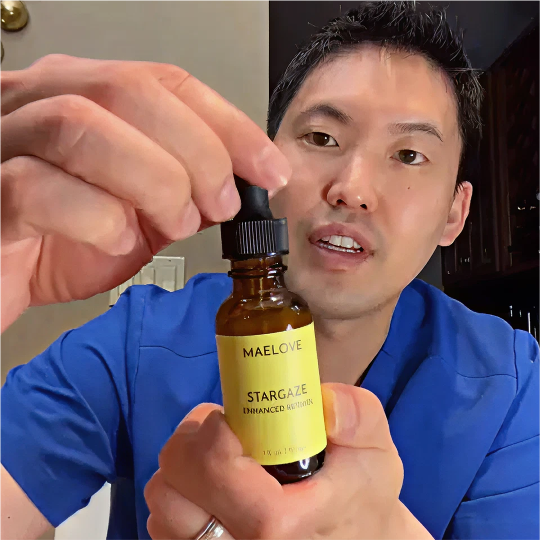 Person in blue holding Maelove Stargaze serum bottle with dropper.