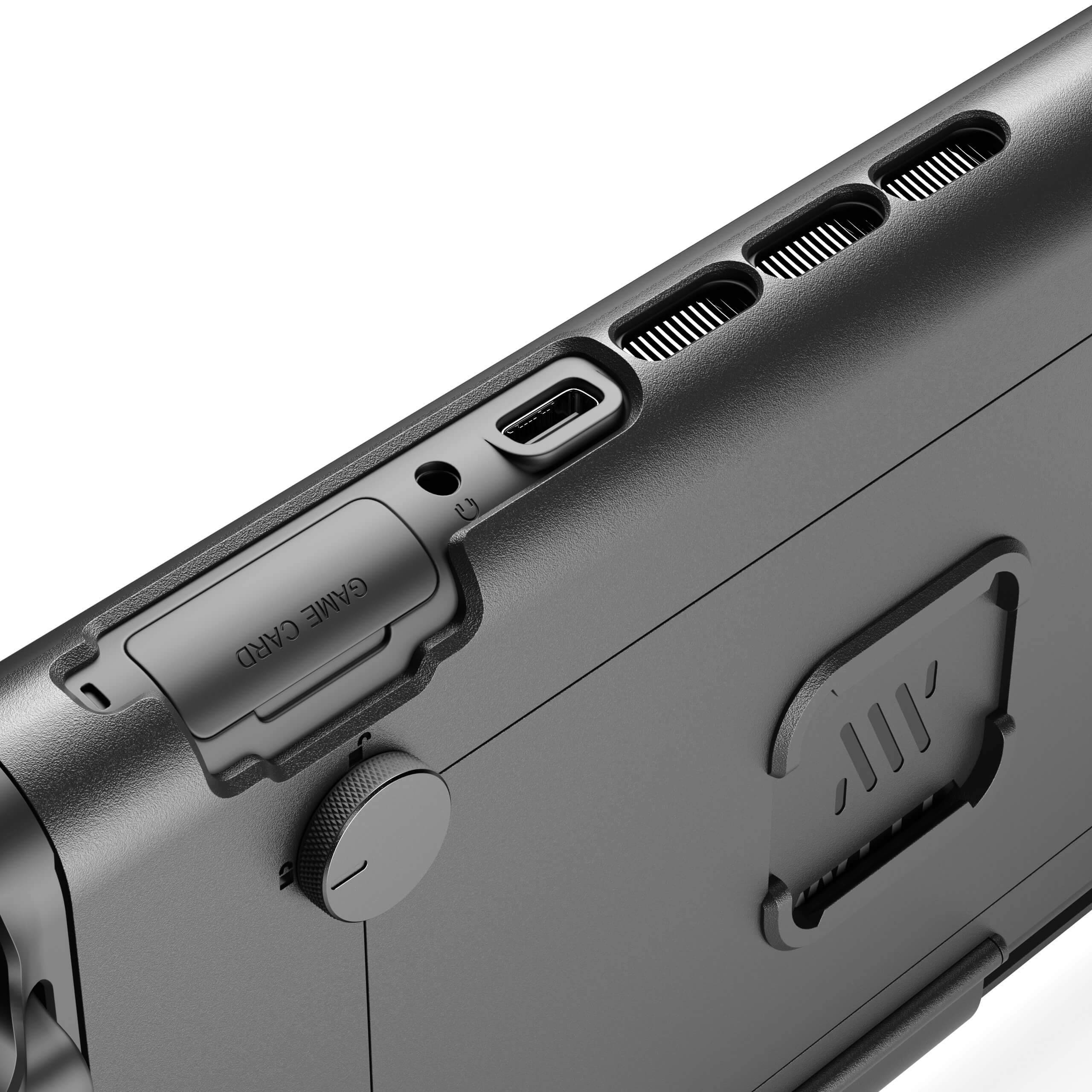 A close-up of the top of a black electronic device, showing ports, vents, and a game card slot.