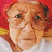 Elderly person wearing glasses and a red hat.