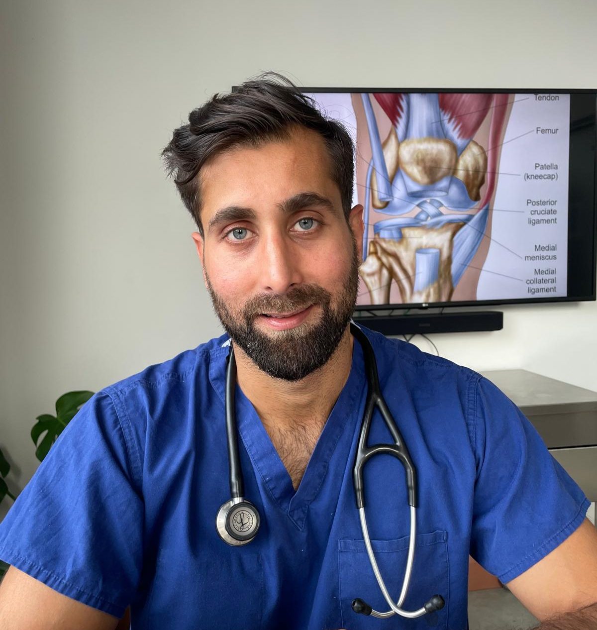 A person in blue scrubs with a stethoscope, anatomical diagram in the background.