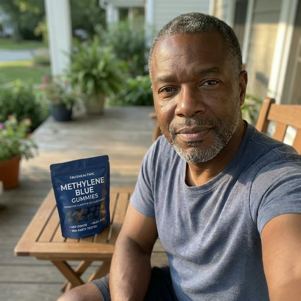 A man sits on a porch with a pouch of Methylene Blue Gummies on a small wooden table.